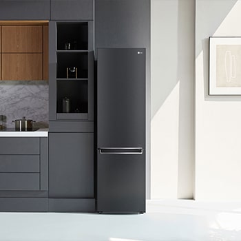 Frigorifero Combinato LG GBB72MCVBN Matte Black, integrato in una moderna cucina dai toni verdi con pavimento in legno e piante.
