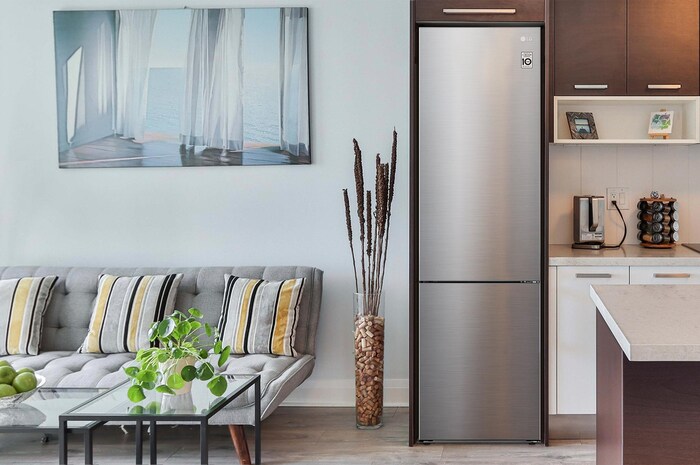 Frigorifero Combinato LG GBP62PZNAC Prime Silver, integrato in una moderna cucina scura con mobili in legno e grigi.