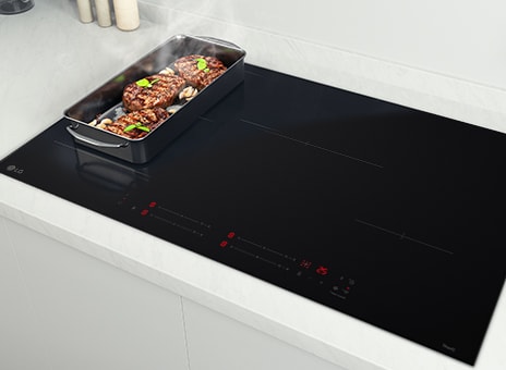 Immagine del piano cottura a induzione con una teglia che occupa due zone in modalità flessibile. Il cibo è fumante.
