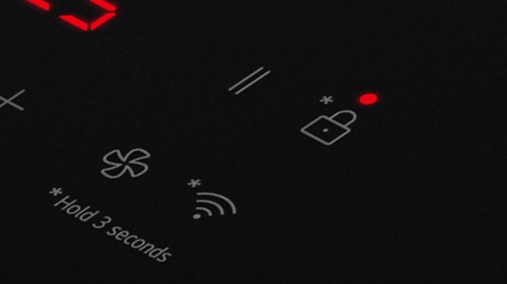 Dettaglio dell'icona del lucchetto accesa sul piano a induzione