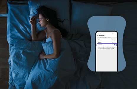 Donna che dorme su un letto con uno smartphone sul cuscino a sinistra che mostra una notifica di "Modalità silenziosa".