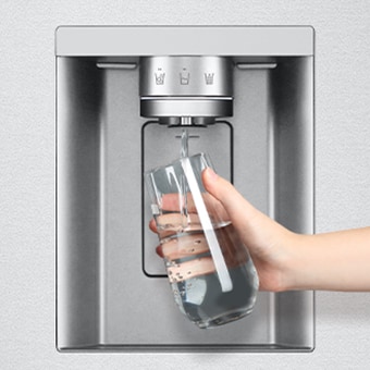Foto di una mano che tiene un bicchiere mentre lo riempie di acqua sotto al dispenser del frigo.