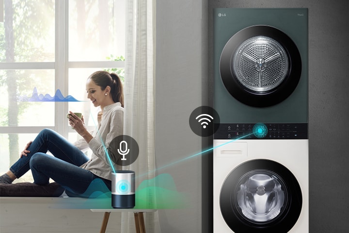 Una donna seduta vicino a una finestra usa un assistente vocale per controllare una lavatrice LG smart a torre.