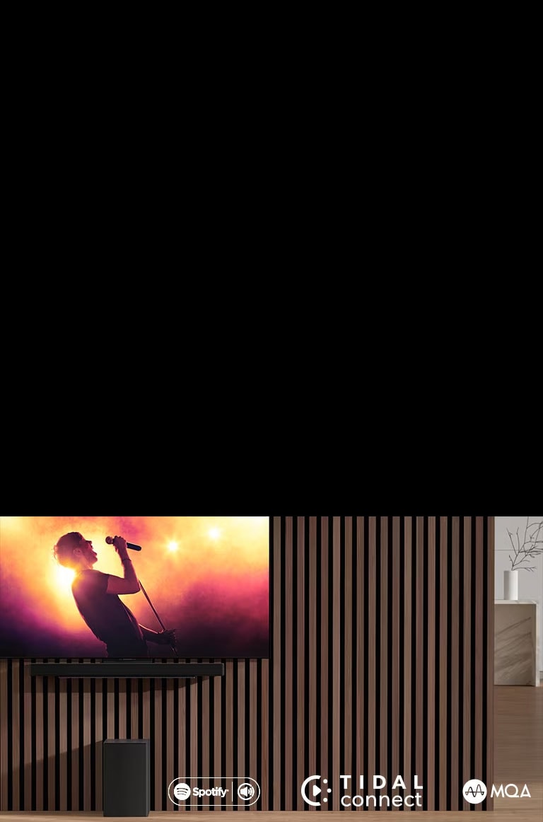 Il dispositivo LG OLED C è posizionato sulla parete, mentre sulla parte inferiore la soundbar SC9S LG è posizionata tramite un'esclusiva staffa. Il subwoofer è posizionato sotto. La TV mostra una scena di concerti.