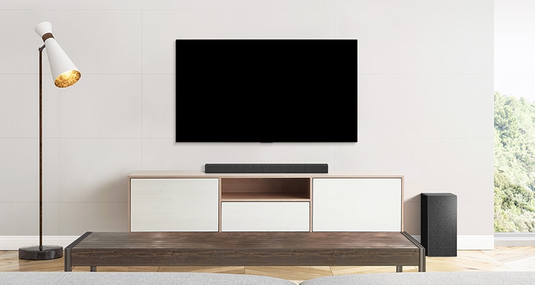 Un TV, una soundbar e un subwoofer collocati in un salotto dal design lineare