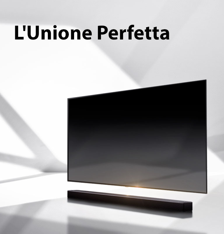 Una soundbar e un TV sono posizionati su un pavimento bianco, appena dietro si vede un’ombra proveniente dall’esterno.