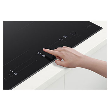 Foto del piano cottura con mano che tocca il display dei comandi LG CBIZ2435B