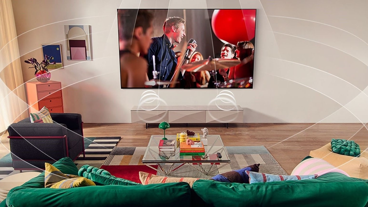 TV con la miglior qualità sonora, immagine di un salotto con TV LG a parete, che trasmette un concerto musicale con audio immersivo Dolby Atmos.
