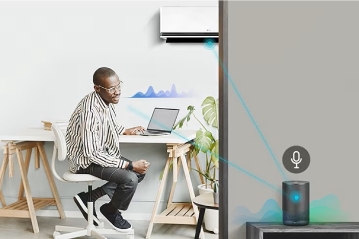 Uomo che lavora in smart working e gestisce il condizionatore LG tramite comandi vocali. 