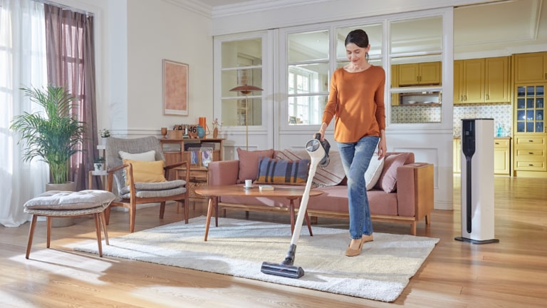 Organizzare le pulizie di casa: immagine di una donna che passa l’aspirapolvere