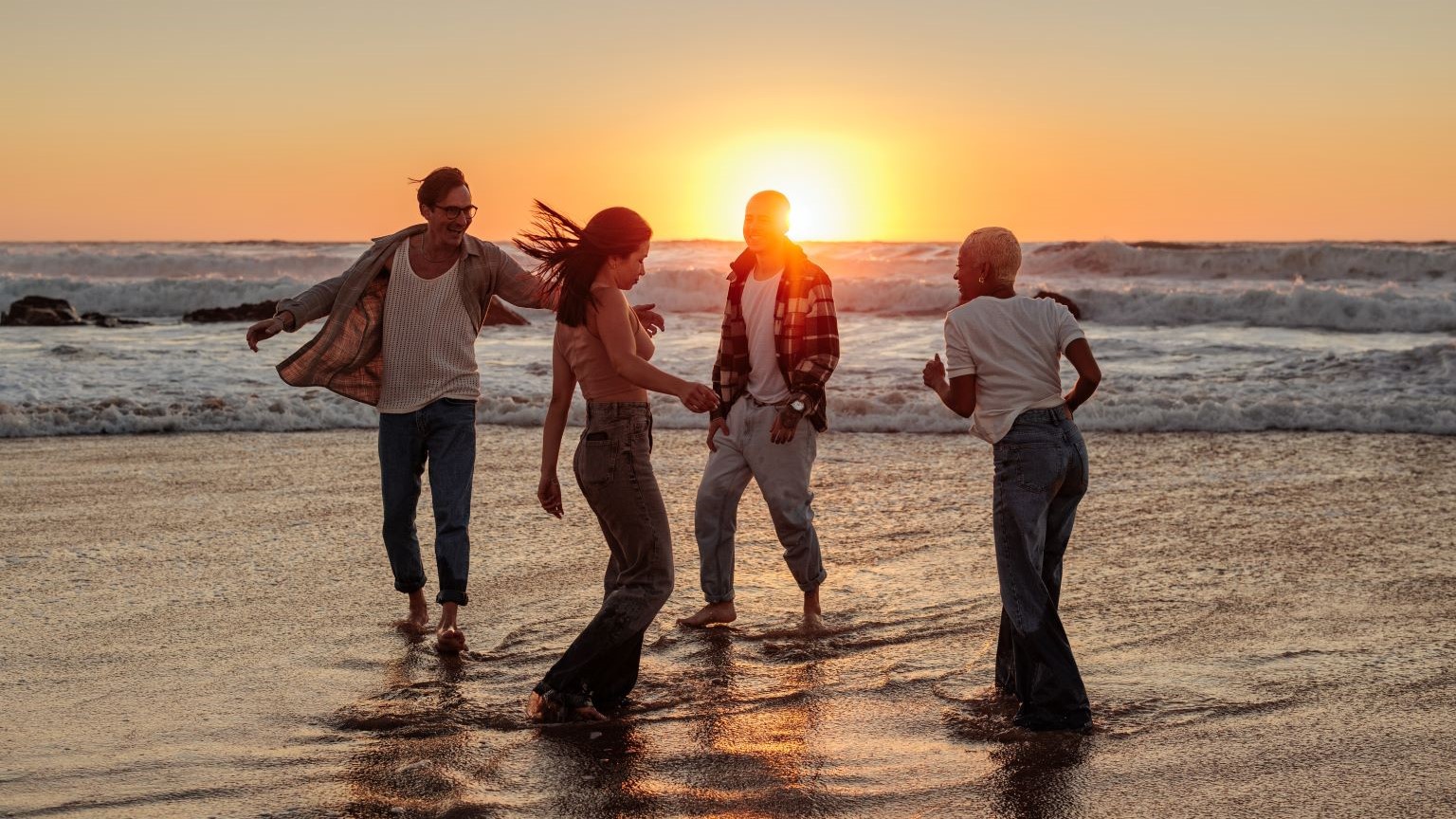 playlist da spiaggia: amici che ballano sulla spiaggia con la musica dalla cassa Xboom LG