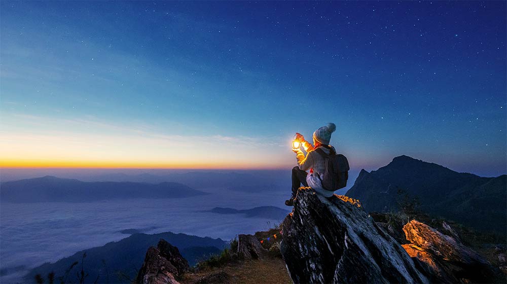 Un video che mostra una donna rannicchiata sul bordo di una montagna. Una linea retta che attraversa lo schermo si trasforma in un'onda, che rappresenta la curva di tono che perfeziona l'immagine.