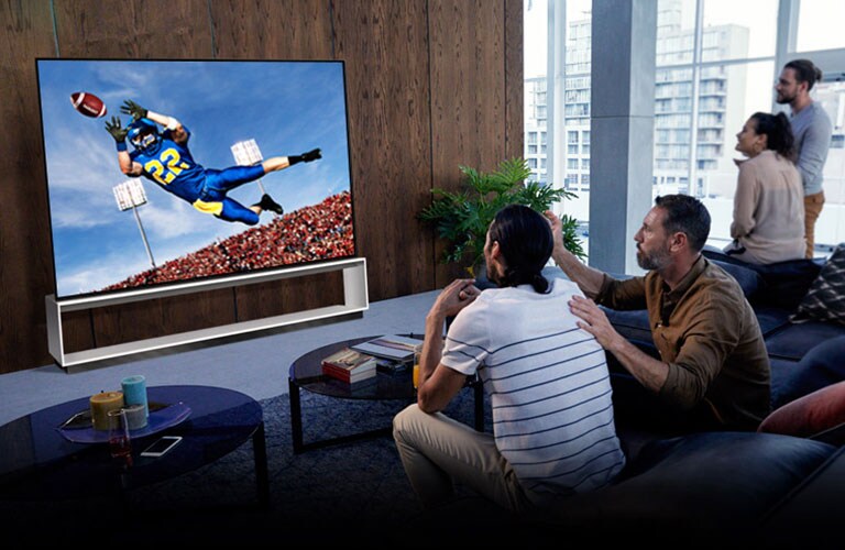 Persone che guardano una partita del Tottenham in TV in soggiorno