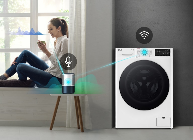 Una donna seduta su un davanzale controlla una lavatrice LG intelligente tramite comandi vocali con un dispositivo.