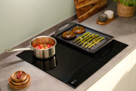 Immagine di un piano cottura su cui c'è un pentolino e una piastra. La piastra sfrutta la zona flex del piano cottura, occupando le due zone a destra.