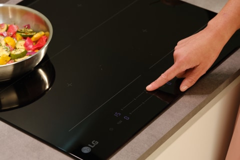 Immagine di un dito che seleziona la potenza del piano cottura.