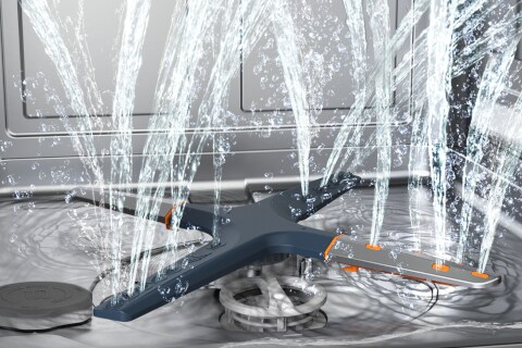 Immagine dell'interno della lavastoviglie in cui si vede il sistema QuadWash composto da 4 bracci irroratori. Dai fori esce l'acqua che si distribuisce ovunque.