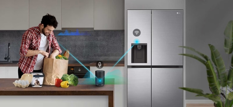 Alt Text: Uomo che mette a posto la spesa in una cucina con un frigorifero smart LG e un altoparlante smart che interagiscono tra loro tramite Wi-Fi.