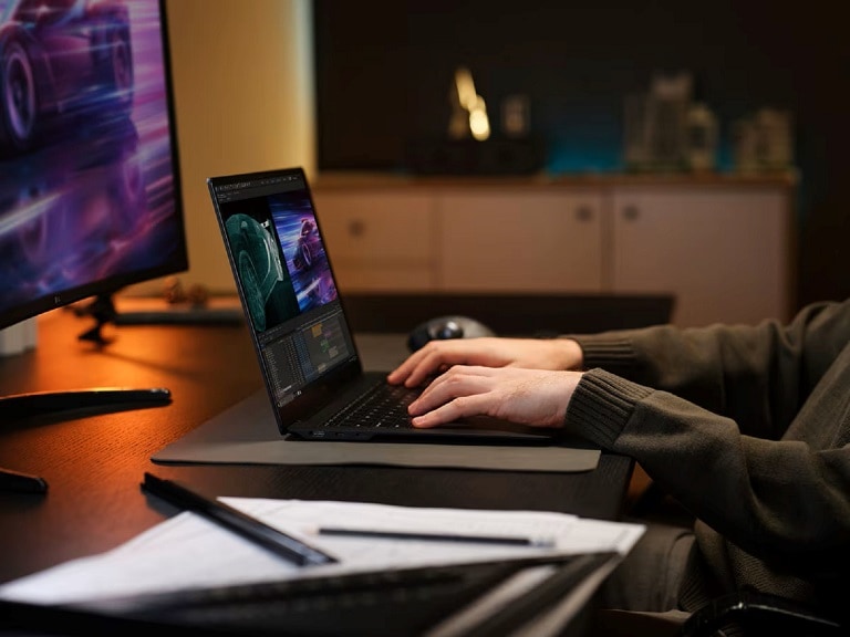 Notebook LG gram Pro con IA che mostra un software di editing video davanti a un monitor più grande.