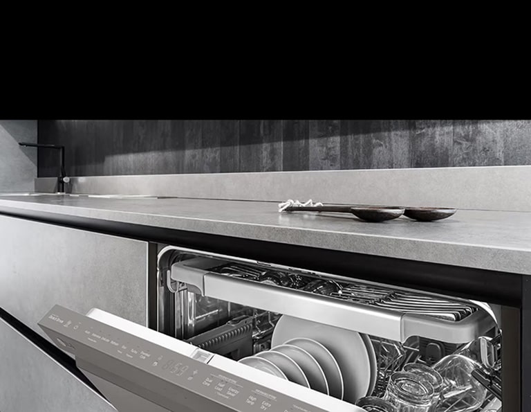 Una cucina moderna con un cassetto della lavastoviglie aperto, che mostra piatti e utensili puliti all'interno, con un elegante piano di lavoro sopra.