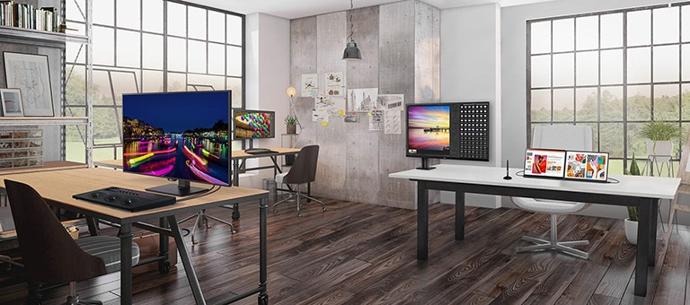 Uno spazio ufficio moderno con grandi finestre industriali, diverse scrivanie con monitor che mostrano immagini colorate. La stanza ha mobili eleganti, scaffali con libri, schizzi alle pareti e piante che aggiungono un tocco naturale.