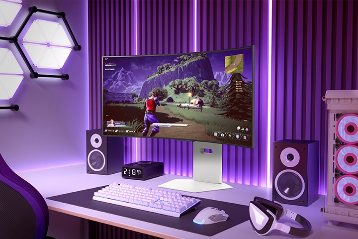 Monitor curvo da gaming che mostra un gioco action-adventure in un setup di gioco vivace con illuminazione viola e una torre PC nelle vicinanze.