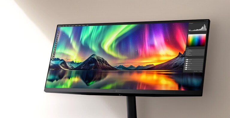 Un monitor LG UltraWide che mostra immagini vivide dell’aurora boreale con un’interfaccia di fotoritocco, evidenziando una vivida precisione dei colori e dettagli ad alta risoluzione.