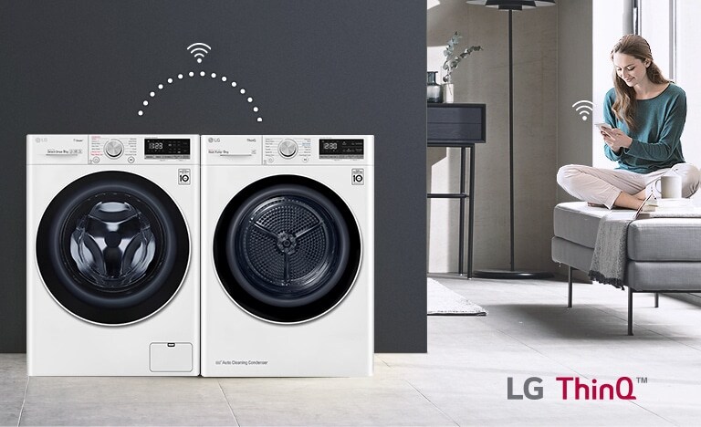  L’utente si siede sul divano e controlla l'asciugatrice e la lavatrice tramite l'app LG ThinQ.