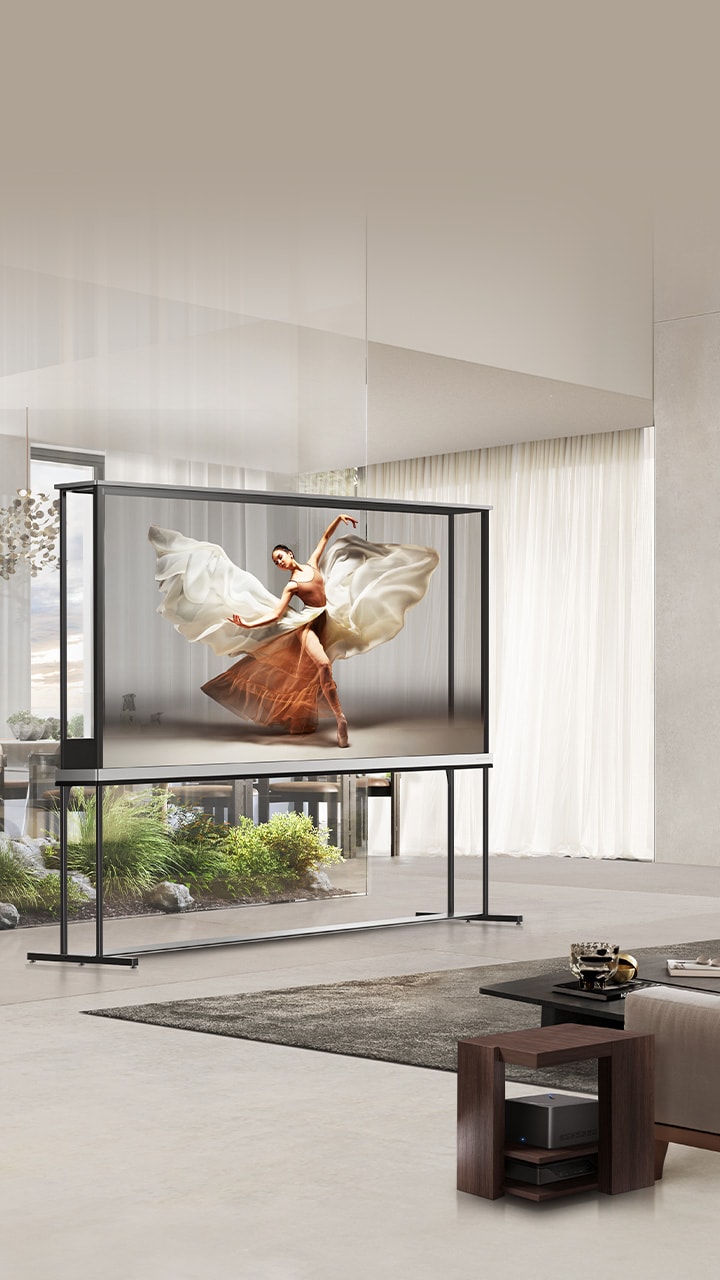 モダンなリビングルームの真ん中に置かれ、ダンサーを映し出しているLG Signature OLED T。ソファの隣に置かれた小さなテーブルの上のZero Connect Box。
