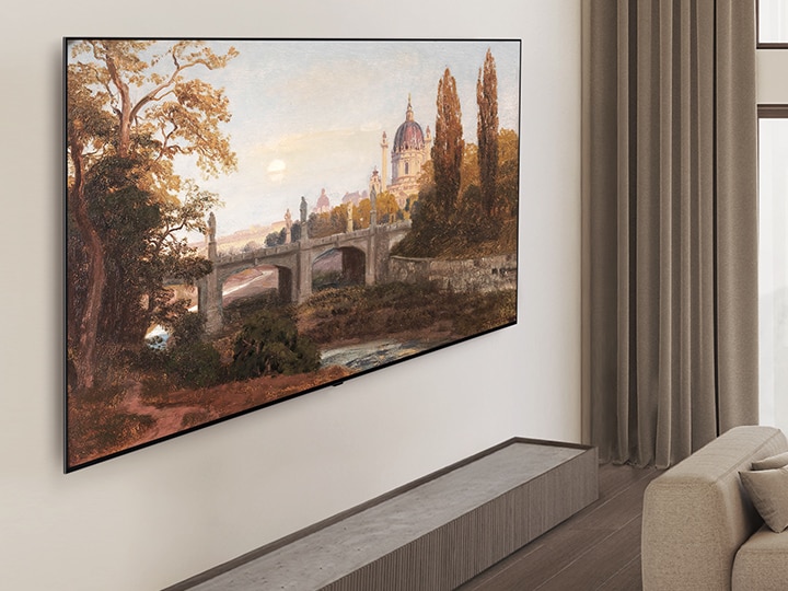 壁掛けのLG OLED TVとLG Soundbarがあるリビングルーム。壁に設置されたTVのスリムなフレームが見える角度の画像。