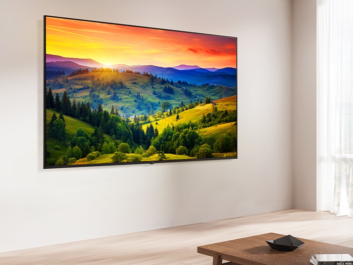 現代的なリビングルーム空間で、LG Soundbarの上に設置されたLG UHD TV。LG UHD TVがカラフルな背景を表示している。