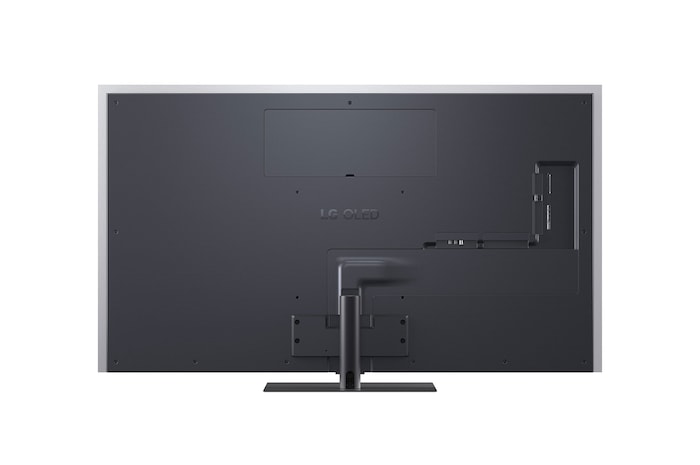 LG OLED evo AI G6 displays a vivid ocean sunset scene, with a soundbar and speaker positioned below the screen, enhancing a calm and atmospheric living space.
