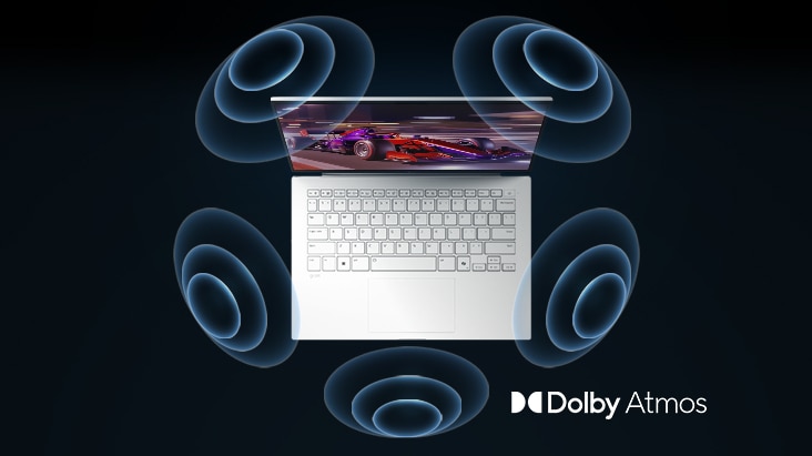 The image shows a top-down view of a laptop with a vibrant, purple-themed graphic on the screen. Surrounding the laptop are dynamic sound wave visuals, indicating an immersive audio experience. The "Dolby Atmos" logo is displayed in the bottom right corner.