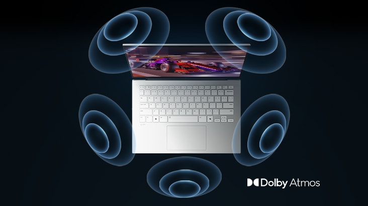 The image shows a top-down view of a laptop with a vibrant, purple-themed graphic on the screen. Surrounding the laptop are dynamic sound wave visuals, indicating an immersive audio experience. The "Dolby Atmos" logo is displayed in the bottom right corner.