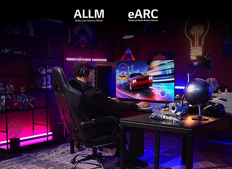 ピンク、青、紫の RGB の照明と、アクションフィギュアのコレクションがあるゲームルームで、男性がドライビングゲームを遊んでいる。