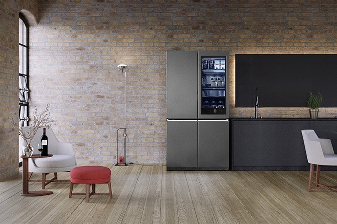 LG SIGNATUREの冷蔵庫をFlexformの家具製品を備えたレンガ造りの倉庫スタイルのキッチンに配置。