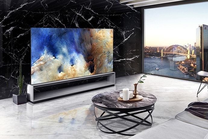 窓の向こうに都市の景色が広がり、スペイン産の大理石ネロマルキーナで飾られたリビングルームにLG SIGNATURE 8K有機ELテレビを設置。