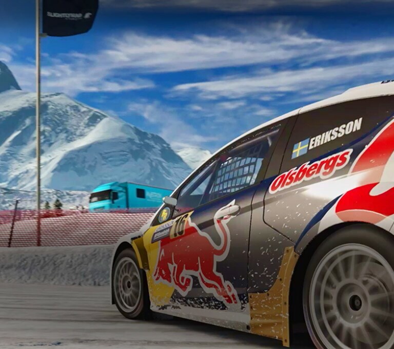レーシングゲームの場面。車が雪に覆われたサーキットでコーナリングしています。