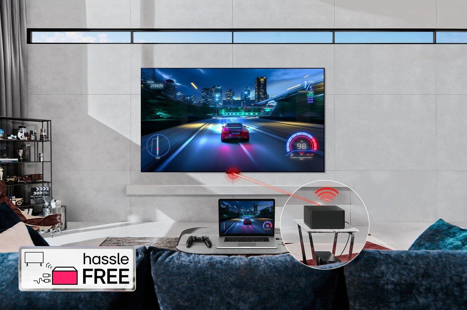 LG OLED evo M4がリビングルームの壁に設置され、その前にあるテーブル上には同じカーレースを表示しているノートパソコンがある。小さめのテーブルの上にあるZero Connect Boxのクローズアップ画像。下部にコンソールが接続され、赤いWi-Fi信号と赤いビームがテレビに向けて放射されている。左下隅に「hassle FREE（ストレスフリー）」の文字が表示されている。
