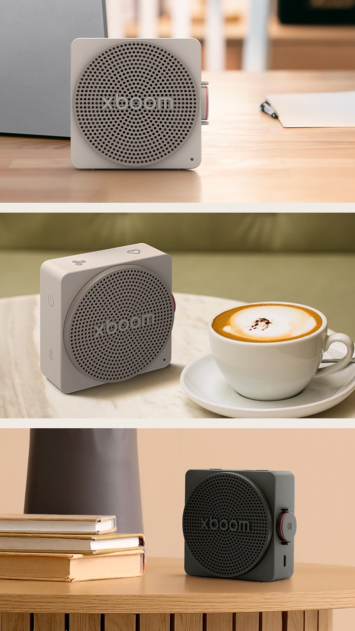 1) Серая компактная портативная Bluetooth-колонка LG xboom Mini, размещенная на столе рядом с ноутбуком, демонстрирует дизайн, гармонично вписывающийся в интерьер 2) Компактная Bluetooth-колонка LG xboom Mini серого цвета на журнальном столике, обеспечивающая объемное звучание дома и на улице 3) Небольшая Bluetooth-колонка LG xboom Mini черного цвета, расположенная среди книг и других предметов, разработанная для удобного повседневного использования