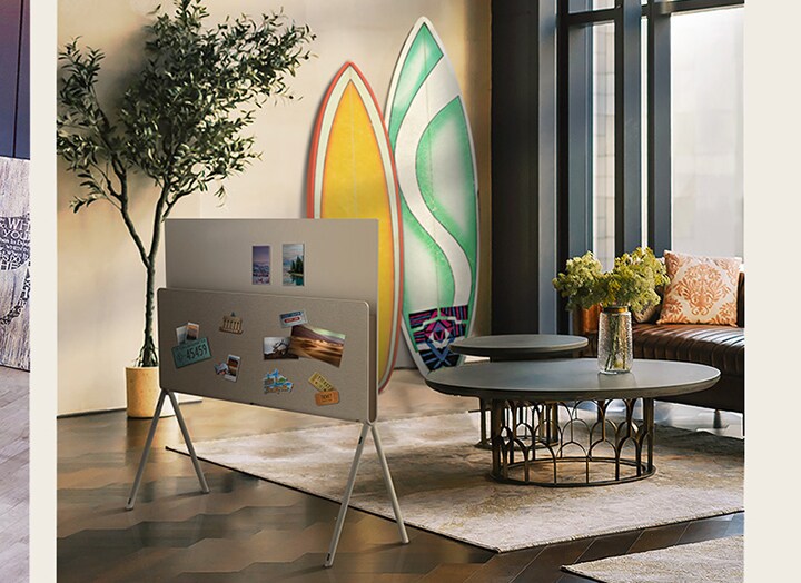 Начинается слайд-шоу, в котором телевизор LG OLED Posé виден сзади с виниловым альбомом и пластинкой, стоящими на медиаполке, рядом с виниловыми пластинками и гитарой. Далее телевизор LG OLED Posé виден сзади с журналами о природе, стоящими на медиаполке в гостиной с растительной тематикой. Затем телевизор LG OLED Posé виден сзади с открытками, наклейками на автомобильных номерах, фотографиями и булавками, размещенными по всей задней поверхности, а сам он находится в теплой, светлой гостиной.