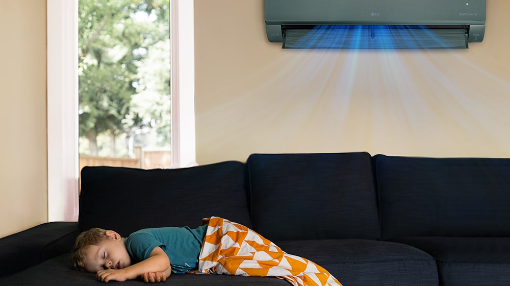 Это изображение ребенка, спящего на диване, а из кондиционера, висящего на стене, дует прохладный ветерок.