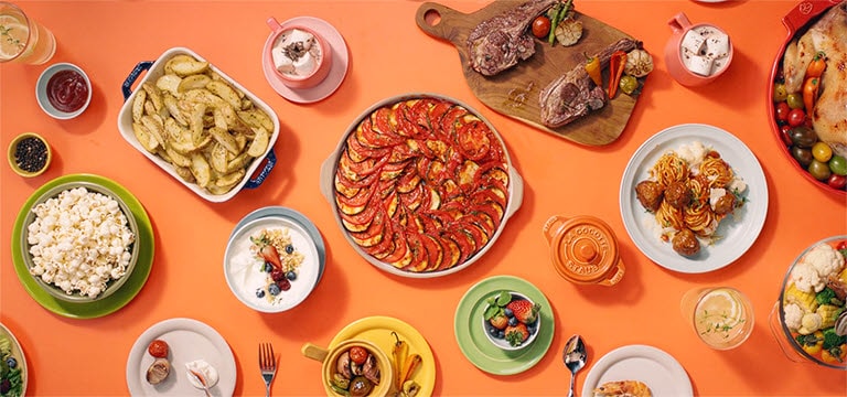 Показаны стоящие на столе разнообразные блюда, приготовленные в LG Neochef.