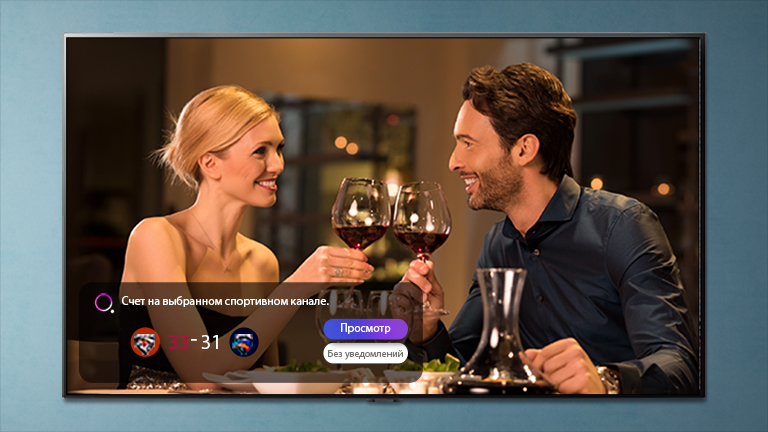 A man and a woman clink their glasses on a TV screen that displays a notification about a sports competition