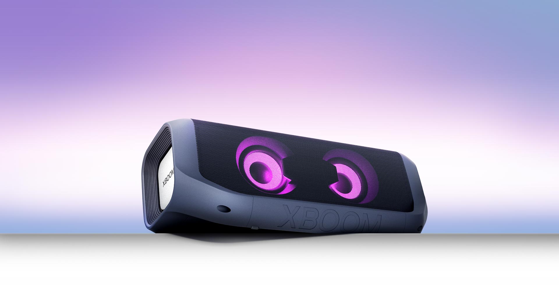 LG XBOOM Go PN7 with magenta lighting against a blue background.