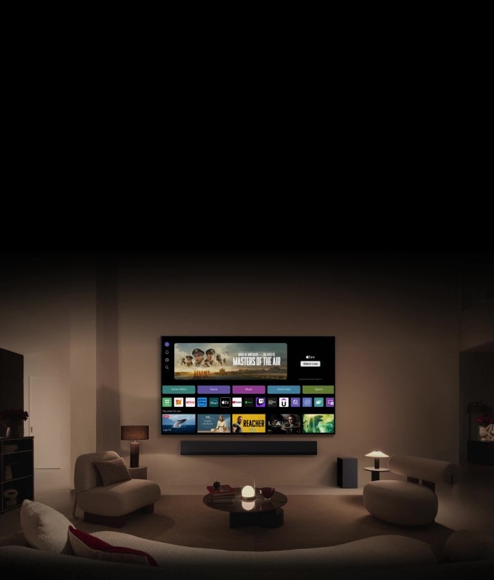 LG TV экранының жақыннан түсірілген суретінде «Үй офисі», «Ойын» және «Музыка» батырмалары бар, ал төменде «Әуе патшалары» телесериалының баннері көрсетілген. Суретте экранның мөлшері кішірейіп, қабырғаға орнатылған теледидар көрсетіледі. Экранда келесі логотиптер: LG Channels, Netflix, Prime Video, Disney TV, Apple TV, YouTube, Spotify, Twitch, GeForce Now және Udemy көрінеді.