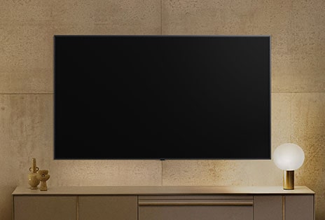 Une LG TV fixée au mur semble éteinte, mais la fonctionnalité Always Ready s’active. Elle affiche des informations, puis passe d’une illustration à l’autre.