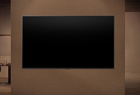 Une LG TV fixée au mur avec son écran éteint montrant comment les capteurs de mouvement de la TV peuvent s’ajuster intelligemment en fonction du mouvement détecté à proximité.