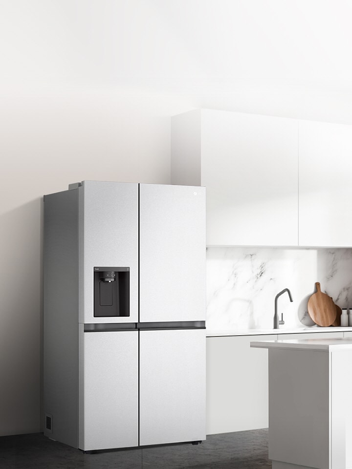 Vue latérale d'une cuisine où est installé un réfrigérateur côte à côte de couleur argent.
