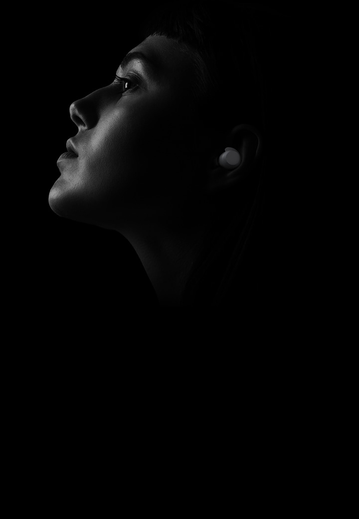 La imagen en blanco y negro muestra a una mujer con unos auriculares xboom en la oreja.